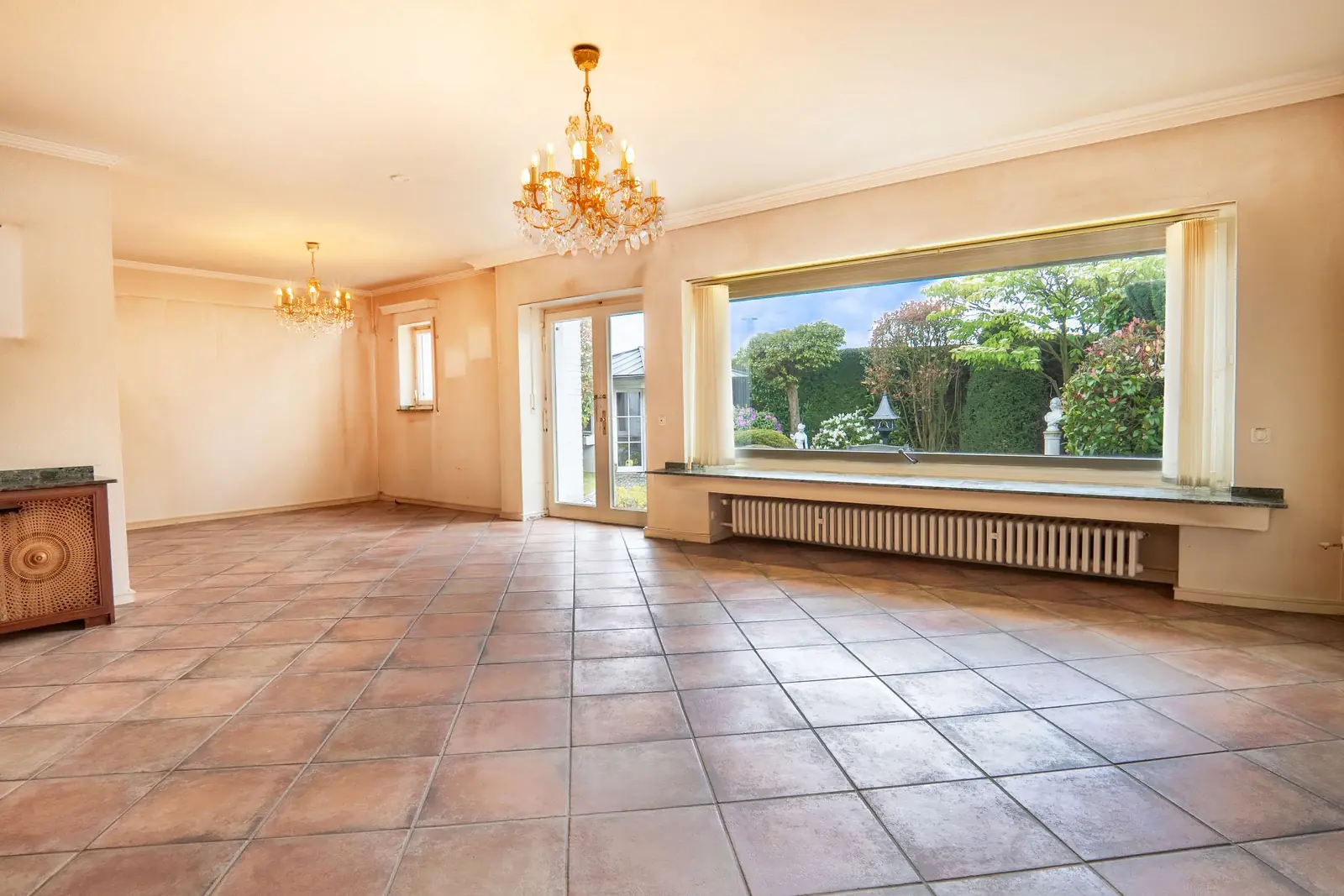 Wohnzimmer mit großer Fensterfront und Gartenblick