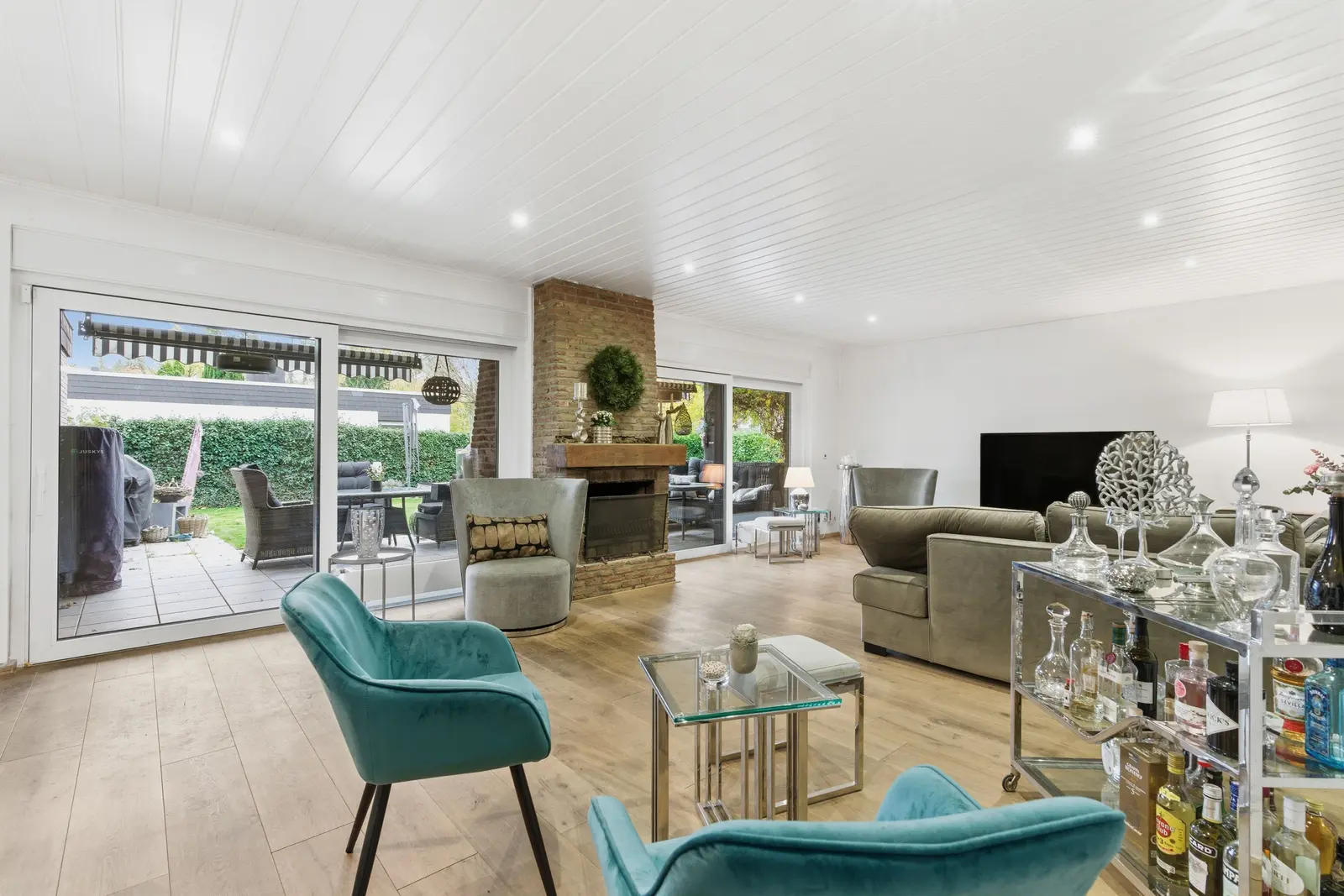 Wohnzimmer mit offenem Kamin und Terrassenzugang