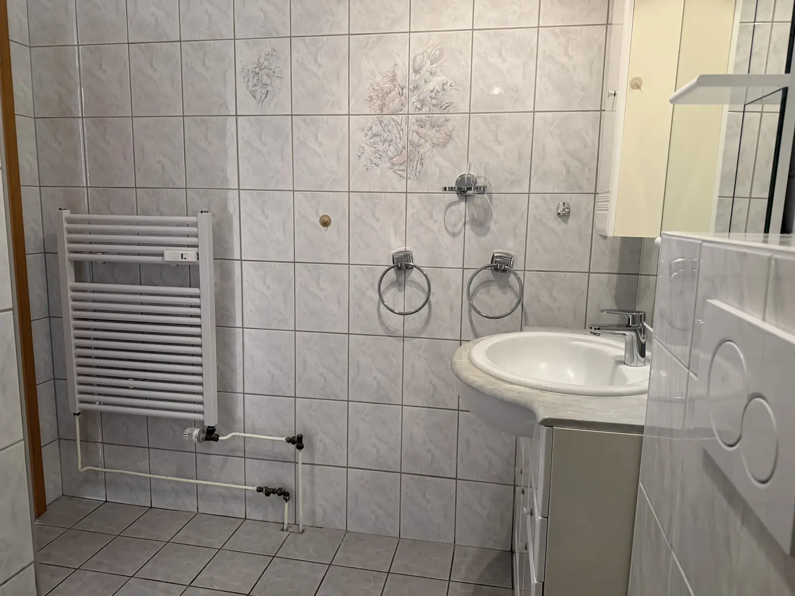 Badezimmer mit Waschbecken und Spiegelschrank