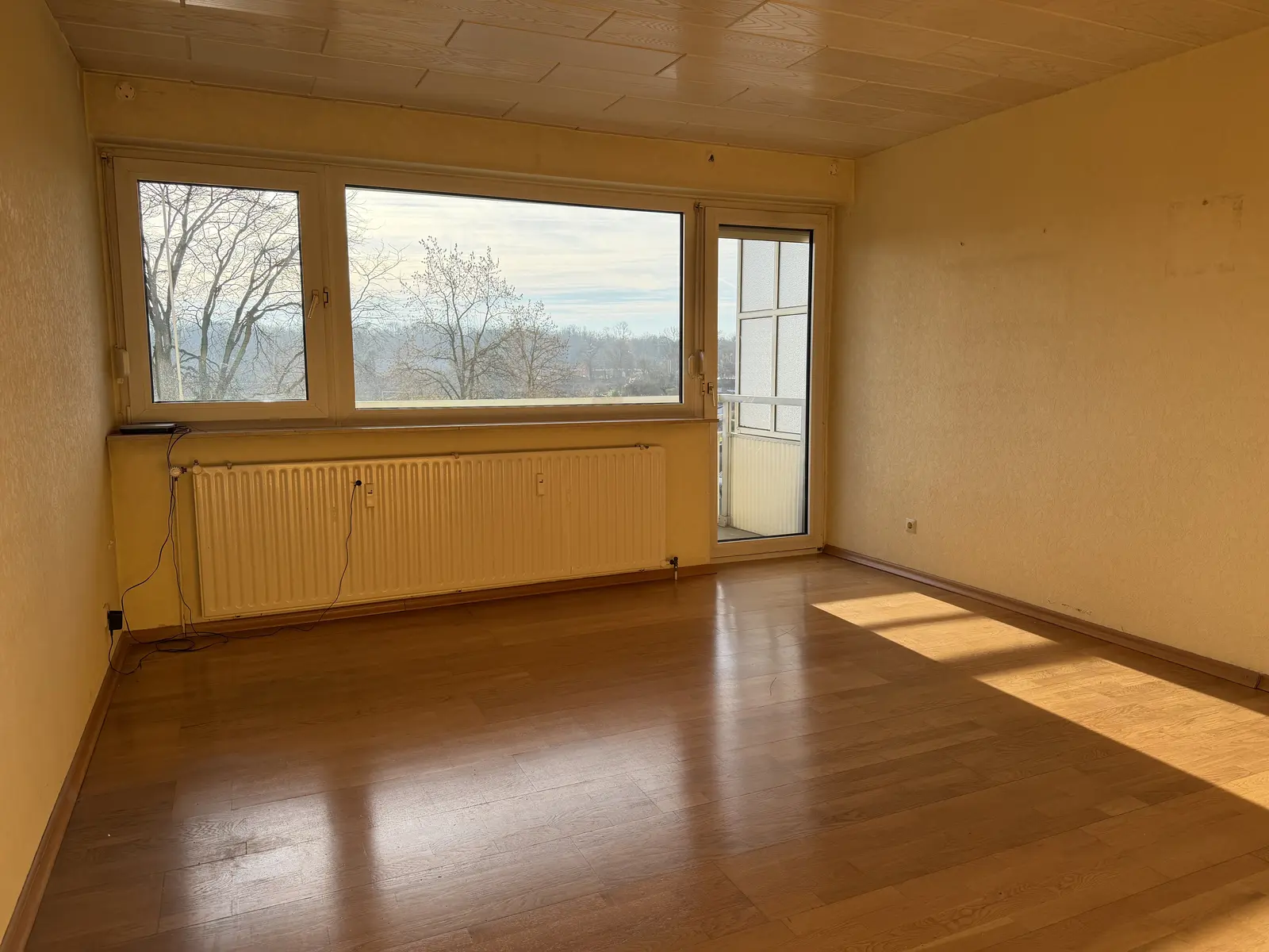 Wohnzimmer mit Panoramafenster und Balkonzugang